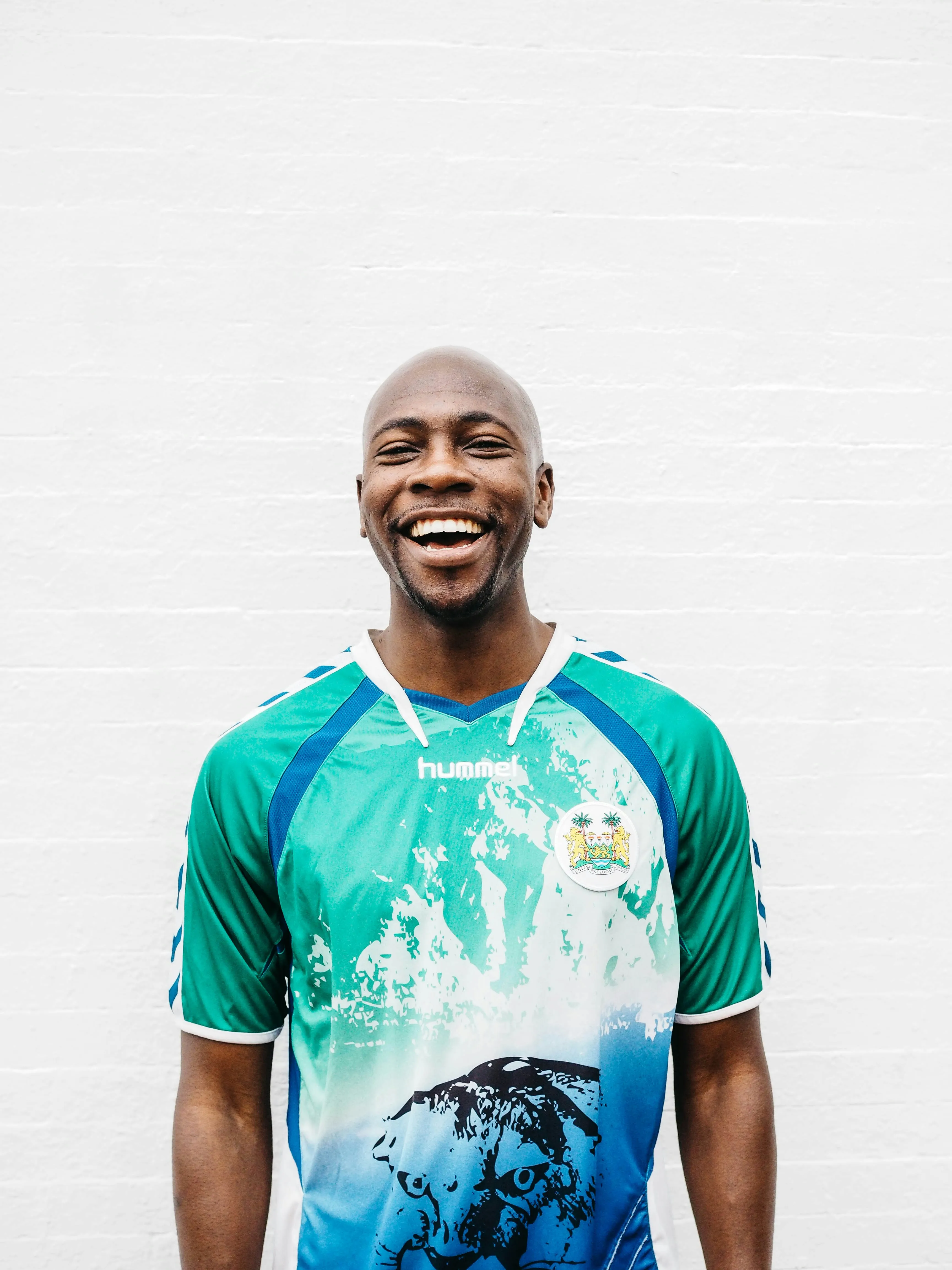 Smiling man in green athletic jersey, close up portrait